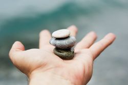 Person's hand with small pile of rocks