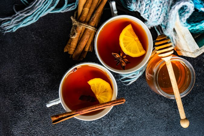 Two tea cups with lemon and star anise and cinnamon stick on red napkin