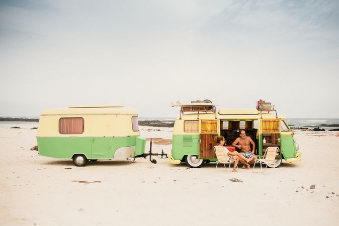 Friends in minibus with trailer on beach