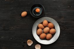Top view of eggs in bowl with one cracked