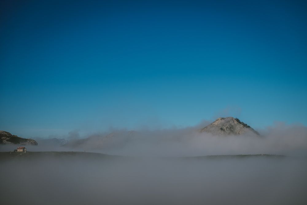 Wonderful view of blue sky above white thick clouds in valley from mountain