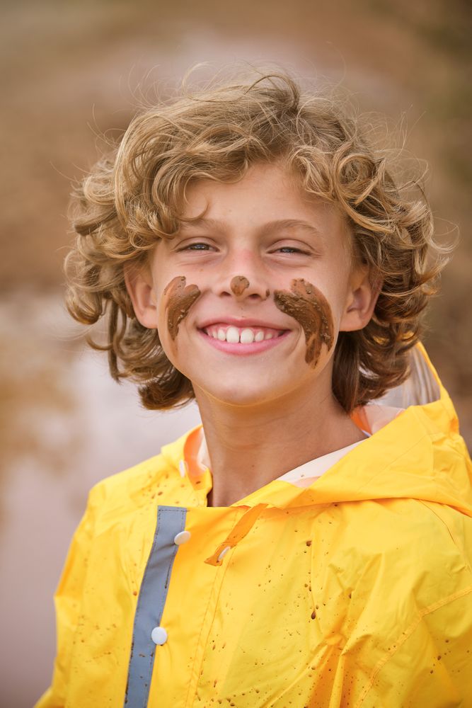 Smiling boy with mud on face