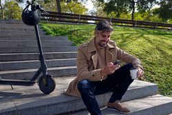 Unshaven man using smartphone in park