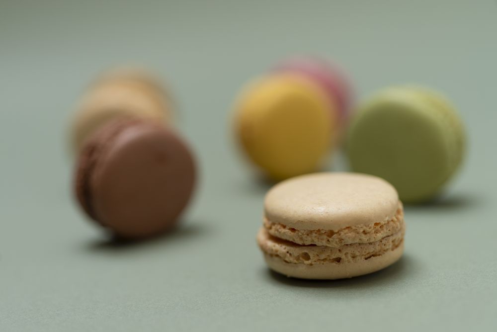 Close up of pastel macaroon desserts on a marble background