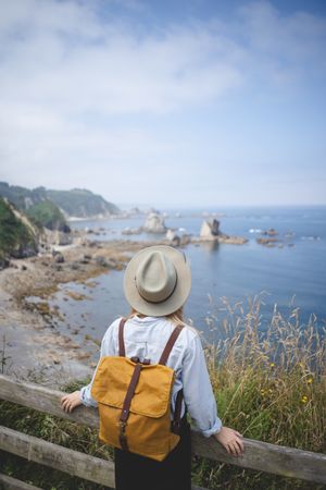 Faceless woman looking on bay from hill
