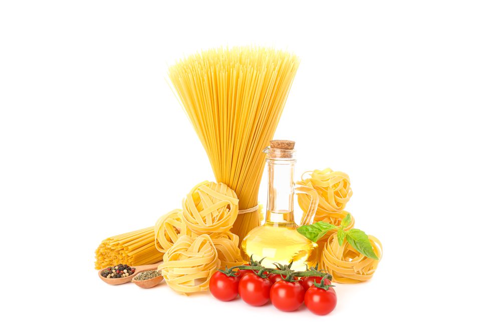 Pasta, olive oil, tomatoes and spice isolated on light background. Uncooked whole wheat pasta