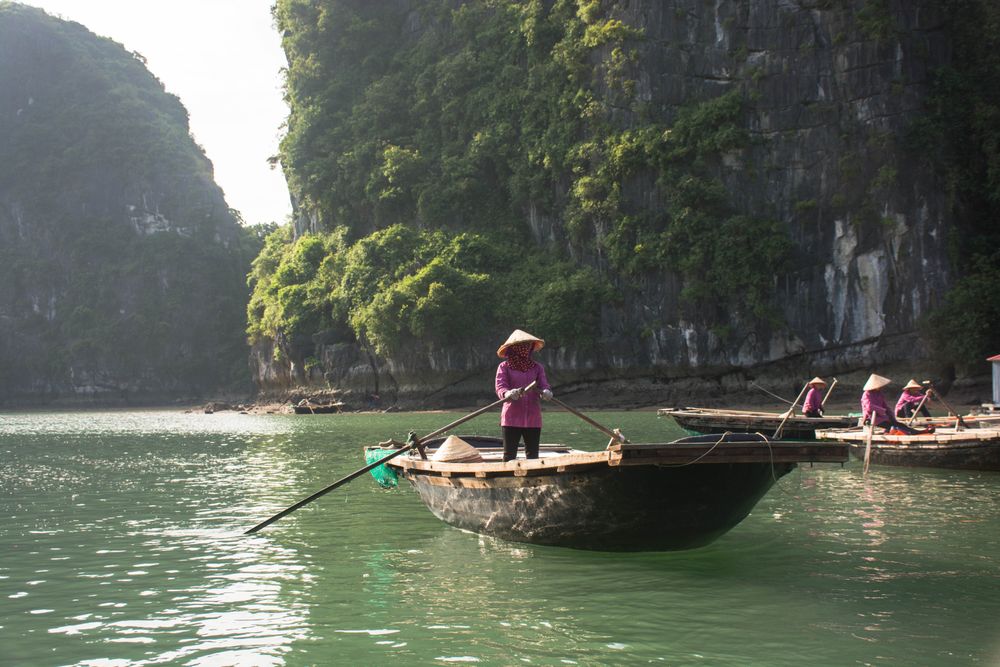 People in conical hats kayaking on body of water