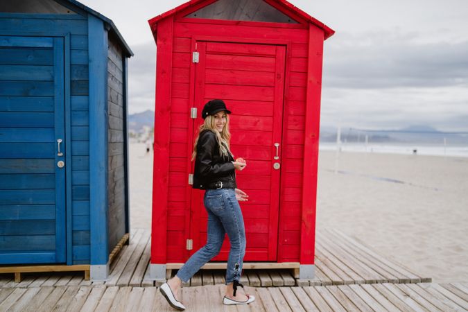 Woman eating an apple near bright wooden cabins