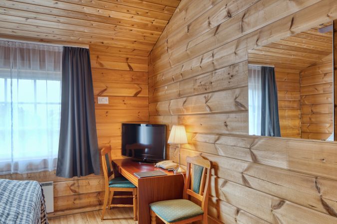 Comfortable hotel interior of bedroom with TV in corner