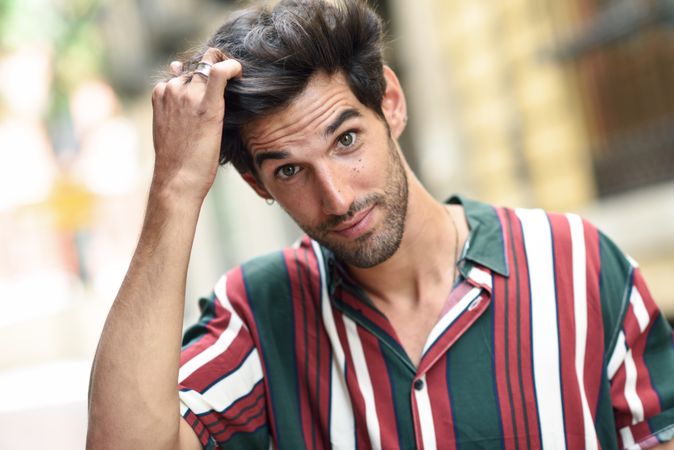 Portrait of dark haired man standing outside