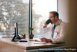 Male doctor drinking coffee at his desk 4AmLE4