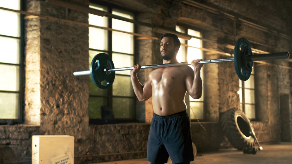 Strong Athletic Shirtless Man Lifts Heavy Barbell as a Part of  Cross Fitness Training Routine.