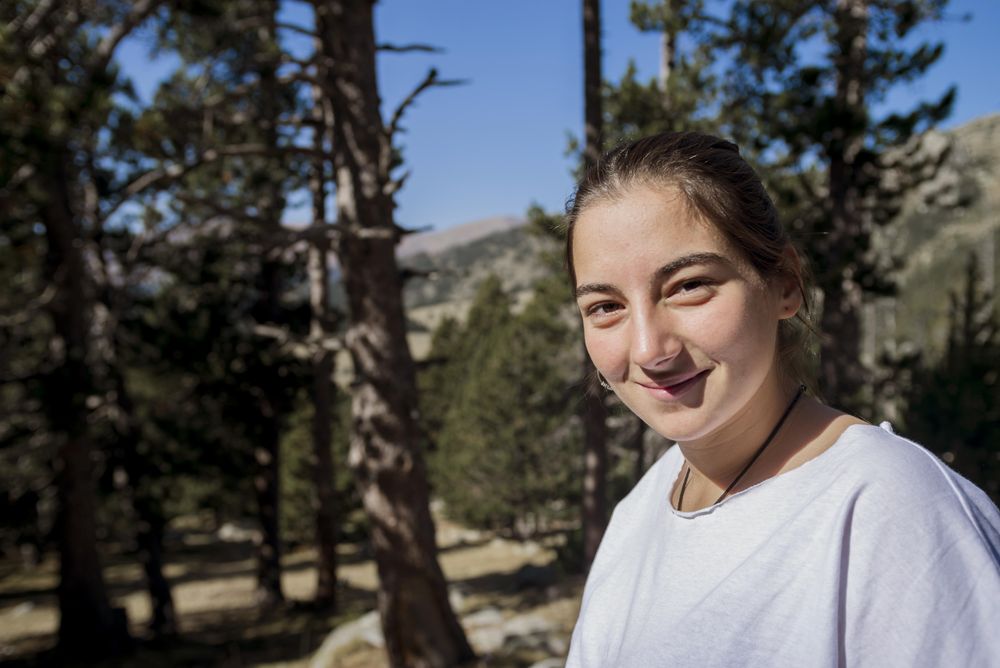 Young woman standing in the woods looking at camera