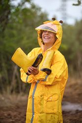 Cheerful boy in waterproof clothes in forest