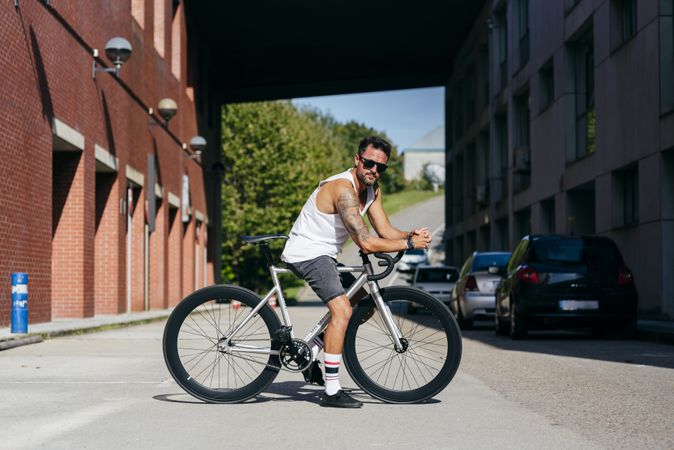 Man riding bike next to buildings