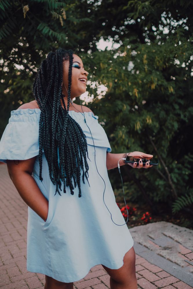 Happy trendy Black woman listening to music