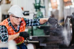 Experienced male operator technician concentrating with lathe