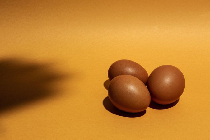 Fresh raw eggs on brown background