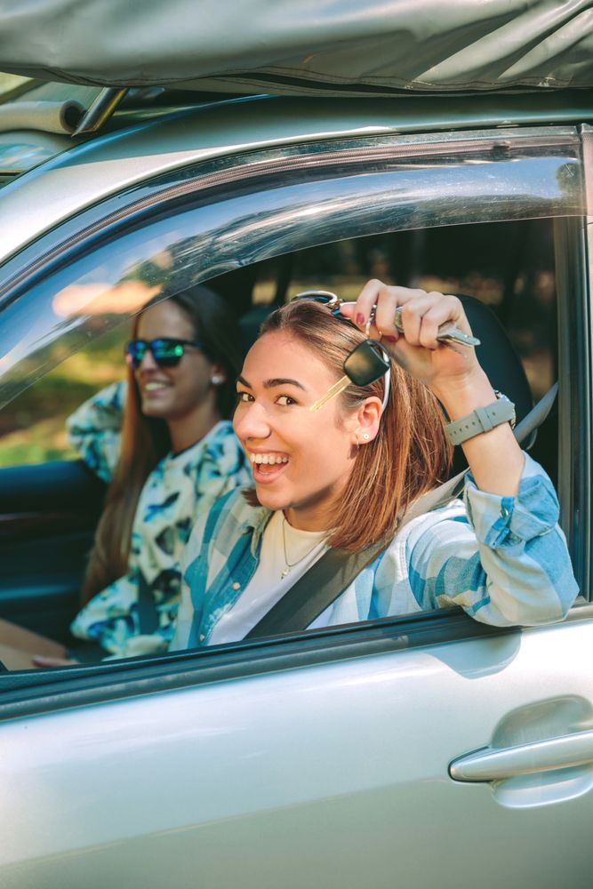Happy woman showing car keys ready to start travel