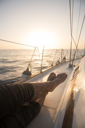 Man lying on edge of yacht on water