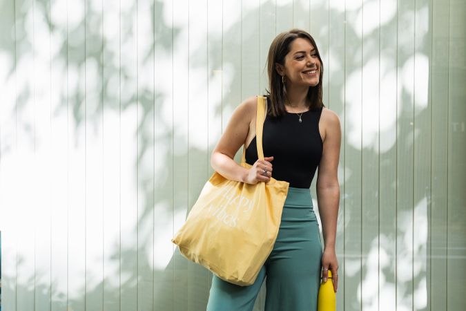Happy woman with eco friendly bag in city