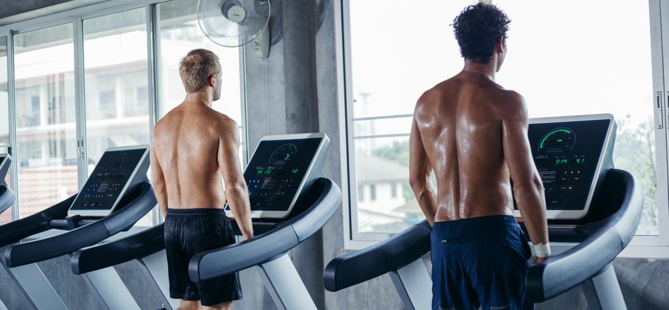 Back of sporty men on treadmill