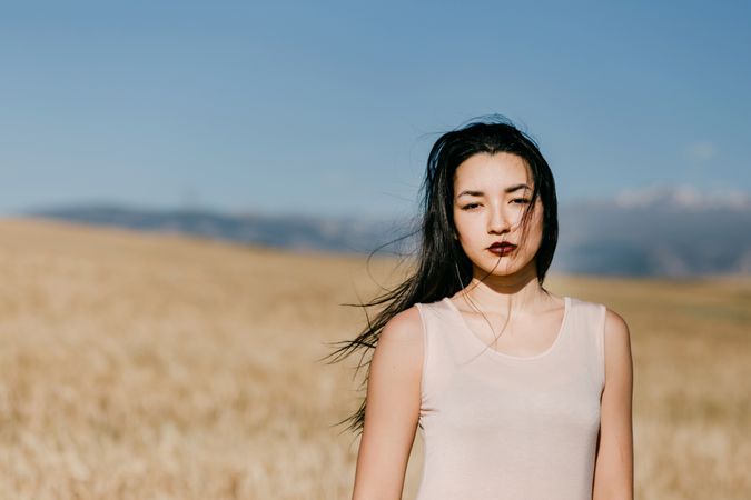 Serious woman standing in field
