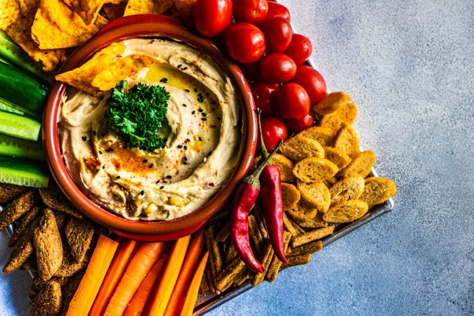Top view of traditional hummus served with fresh veggies