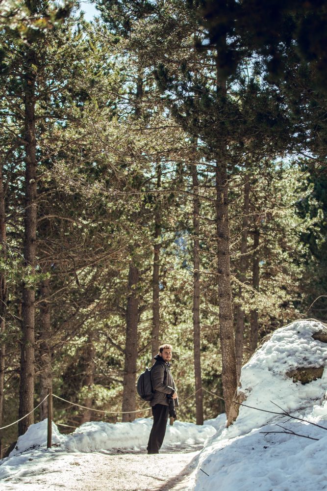 Man between winter forest in sunny day