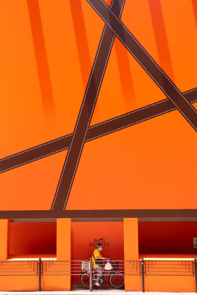 Man riding a bike in an orange building in Hong Kong