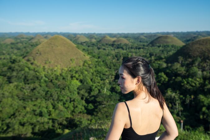 Happy woman standing on observation deck on hill