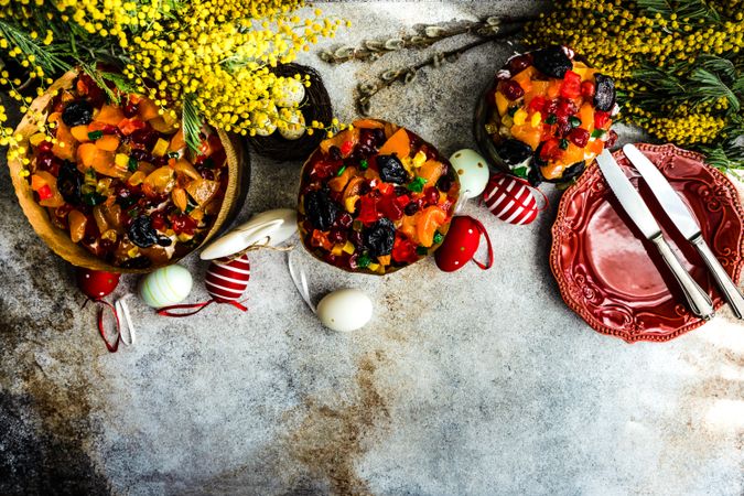 Top view of Easter fruit cakes with decorative eggs and spring flowers