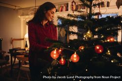 Woman decorating holiday tree 4dmVEb