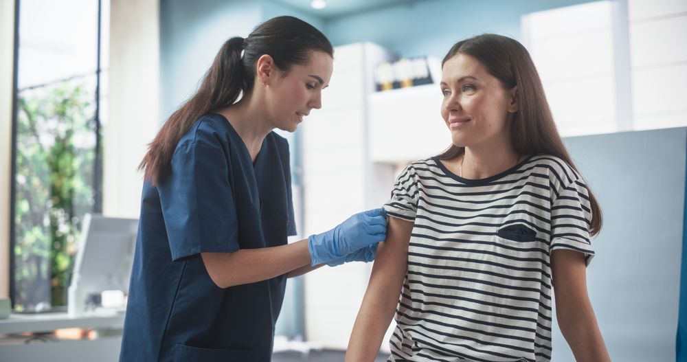 Professional Female Nurse Is Performing Injection And Putting A Patch On. Public Healthcare Concept.