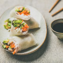 Thai spring rolls on dish beside dipping sauce