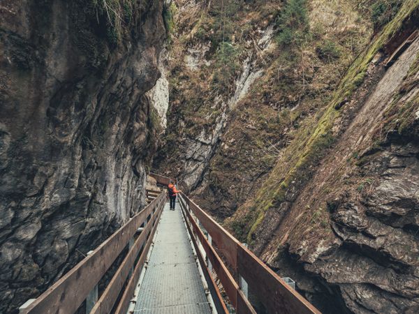 Tourist on hiking path among rocky slopes