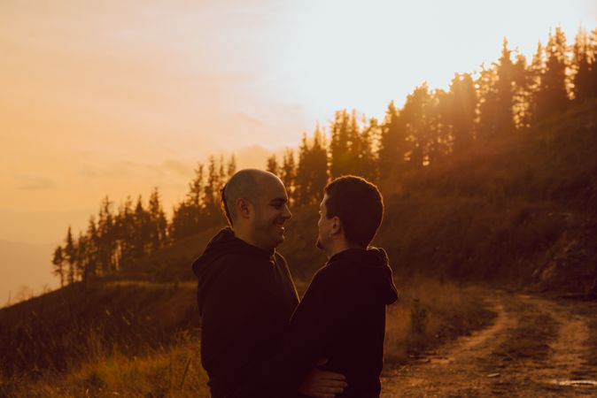 Men hugging and kissing in forest
