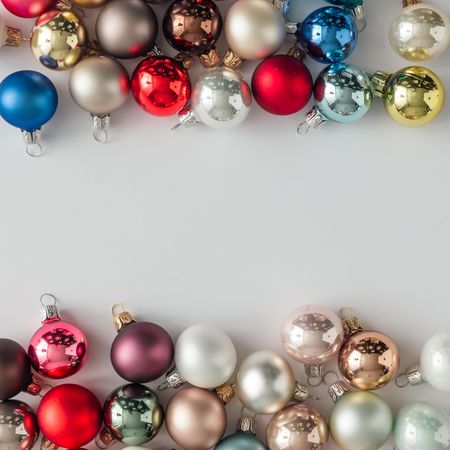 Colorful bauble decorations bordering light background
