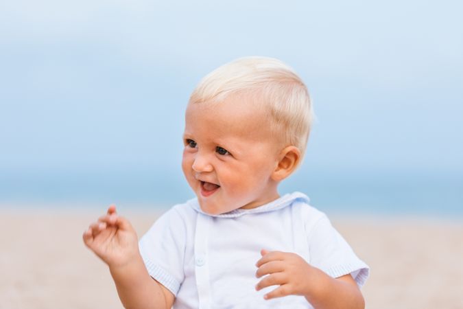 Portrait of a blonde baby smiling on the beach