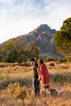 Happy active couple playing with dog outdoors