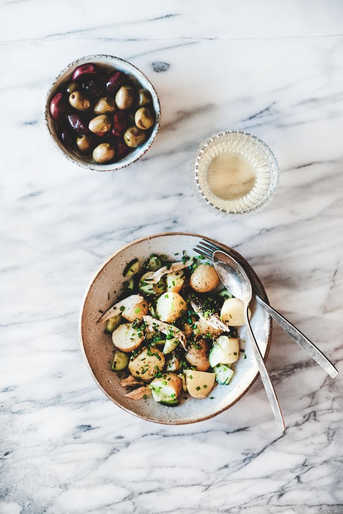 Greek style potato salad, olive bowl and wine, top view