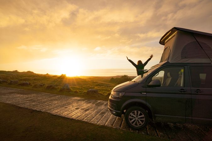 Man with opening hands standing on caravan