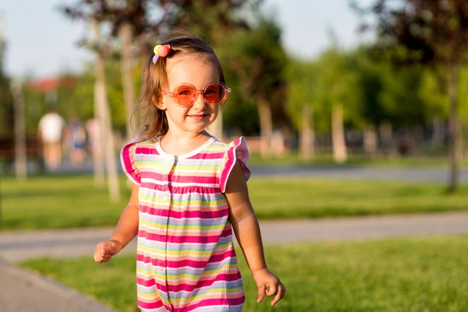 Summery toddler enjoying grass outdoors