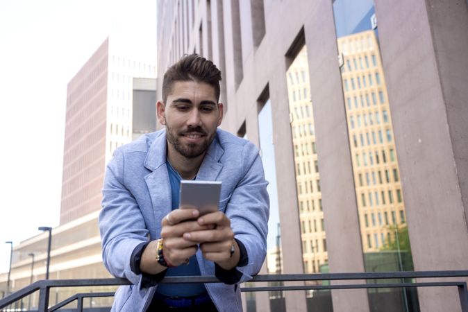 Portrait of Handsome young man smiling using his mobile phone