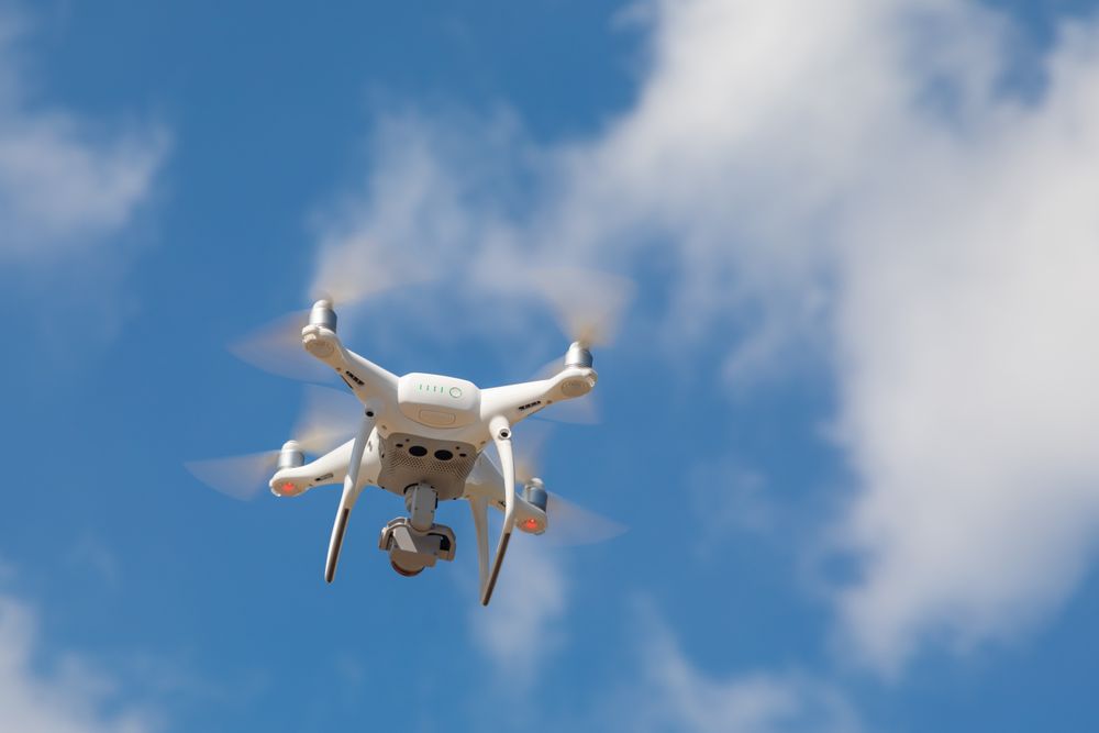 Drone Quadcopter From Below Against A Blue Sky