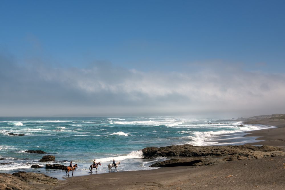 Horseback riding on a rocky beach in Northern California