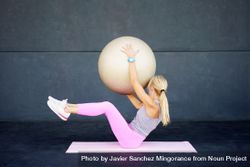 Woman doing mat workout with stability ball 0v3Xag