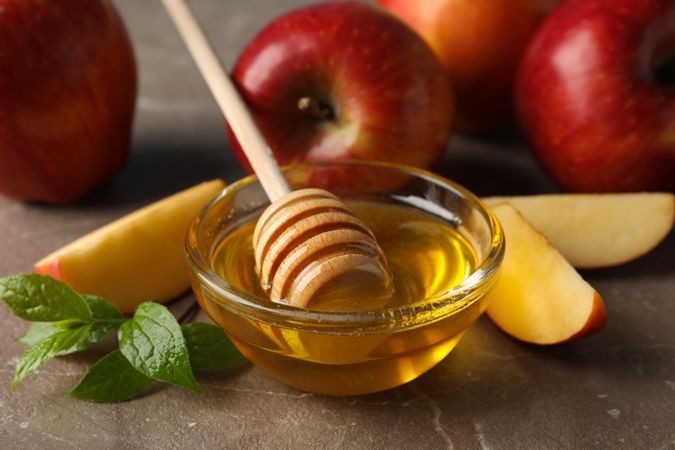 Close up side view of apples and honey in kitchen