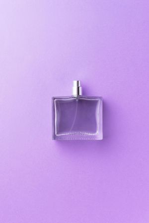 Perfume bottle over purple background