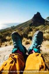 Personal perspective of woman hiker resting on mountain trail 0LDVE0